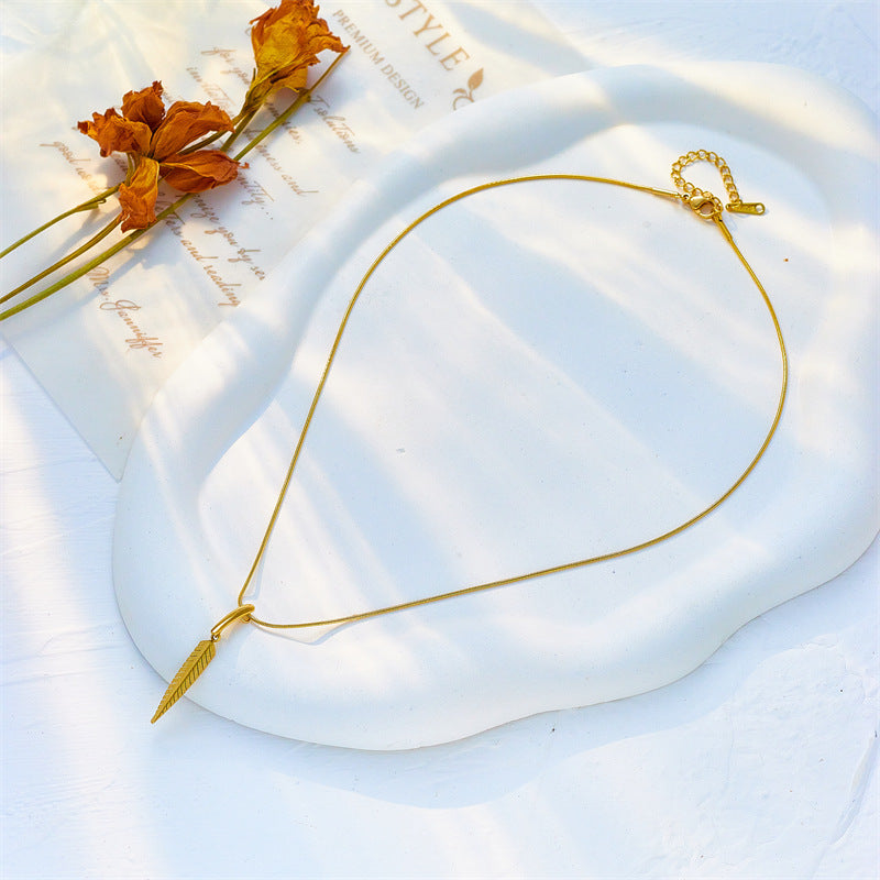 Gold necklace on a white fabric background with dried flowers